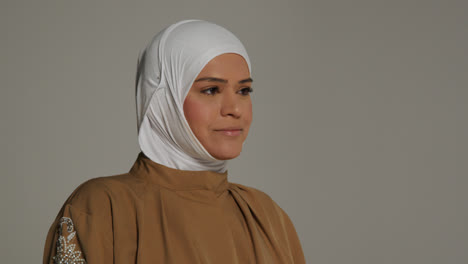 Studio-Head-And-Shoulders-Portrait-Of-Smiling-Muslim-Woman-Wearing-Hijab